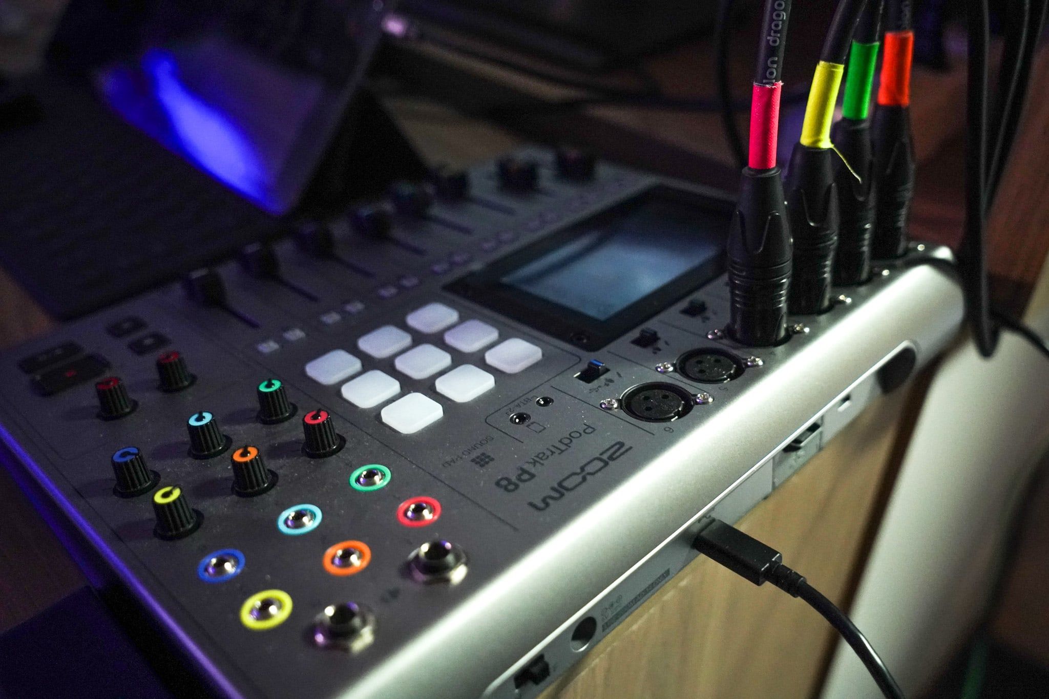 Gravador de áudio Zoom PodTrak P8 com quatro cabos XLR coloridos conectados.