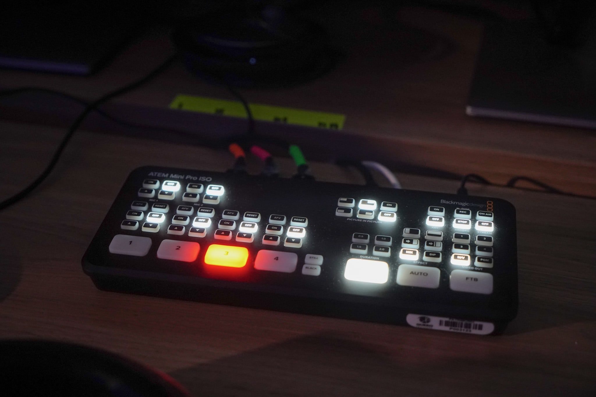 Mesa de corte Blackmagic ATEM Mini Pro ISO sobre a bancada, com um botão de câmera aceso em vermelho.